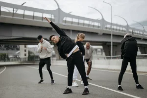 Adultos haciendo estiramientos en una sesión de entrenamiento al aire libre